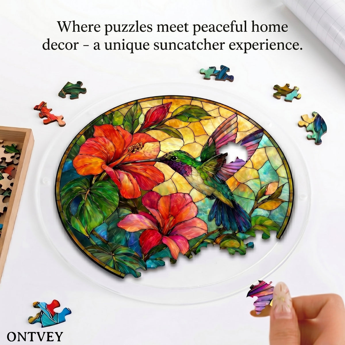 Hands assembling the Hummingbird acrylic jigsaw puzzle suncatcher on a table