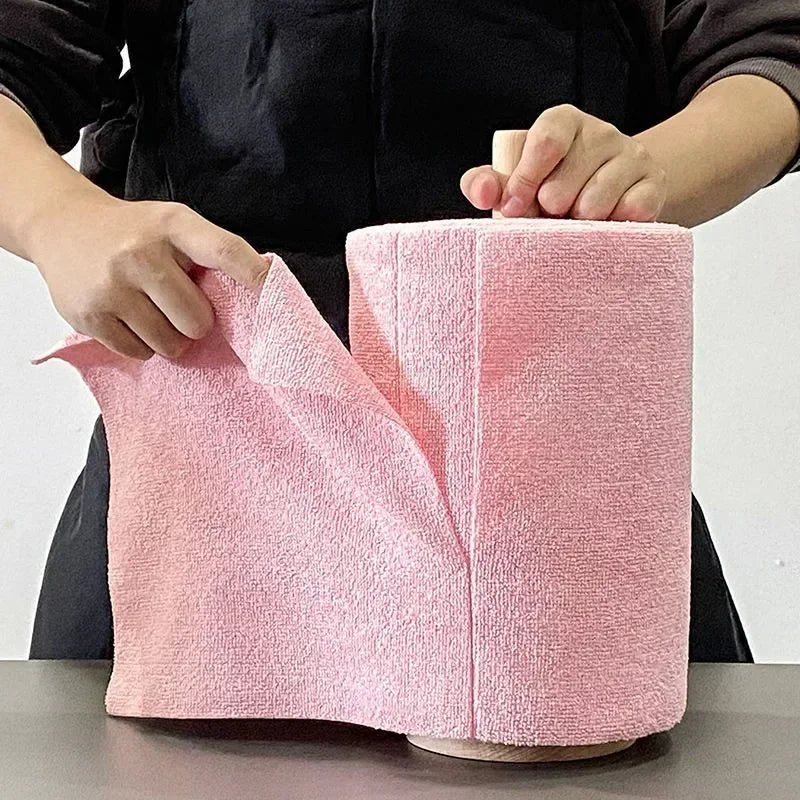 Hands tearing a sheet from a pink microfiber towel roll