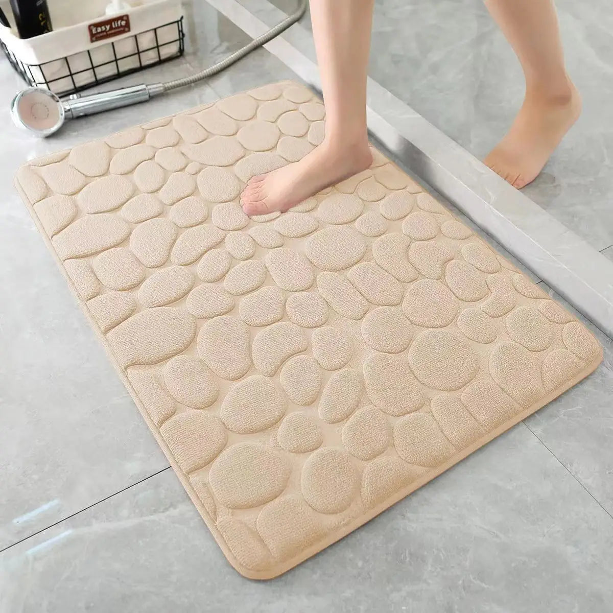 Beige cobblestone bath mat on a bathroom floor