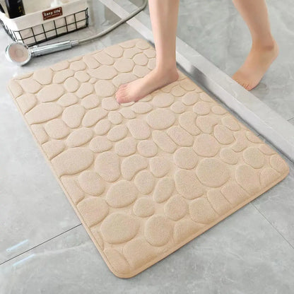 Beige cobblestone bath mat on a bathroom floor