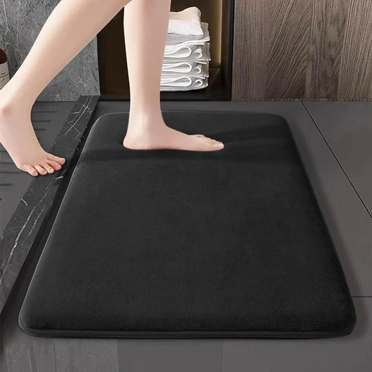 Black super absorbent bath mat on a bathroom floor