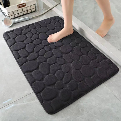 Black cobblestone bath mat on a bathroom floor