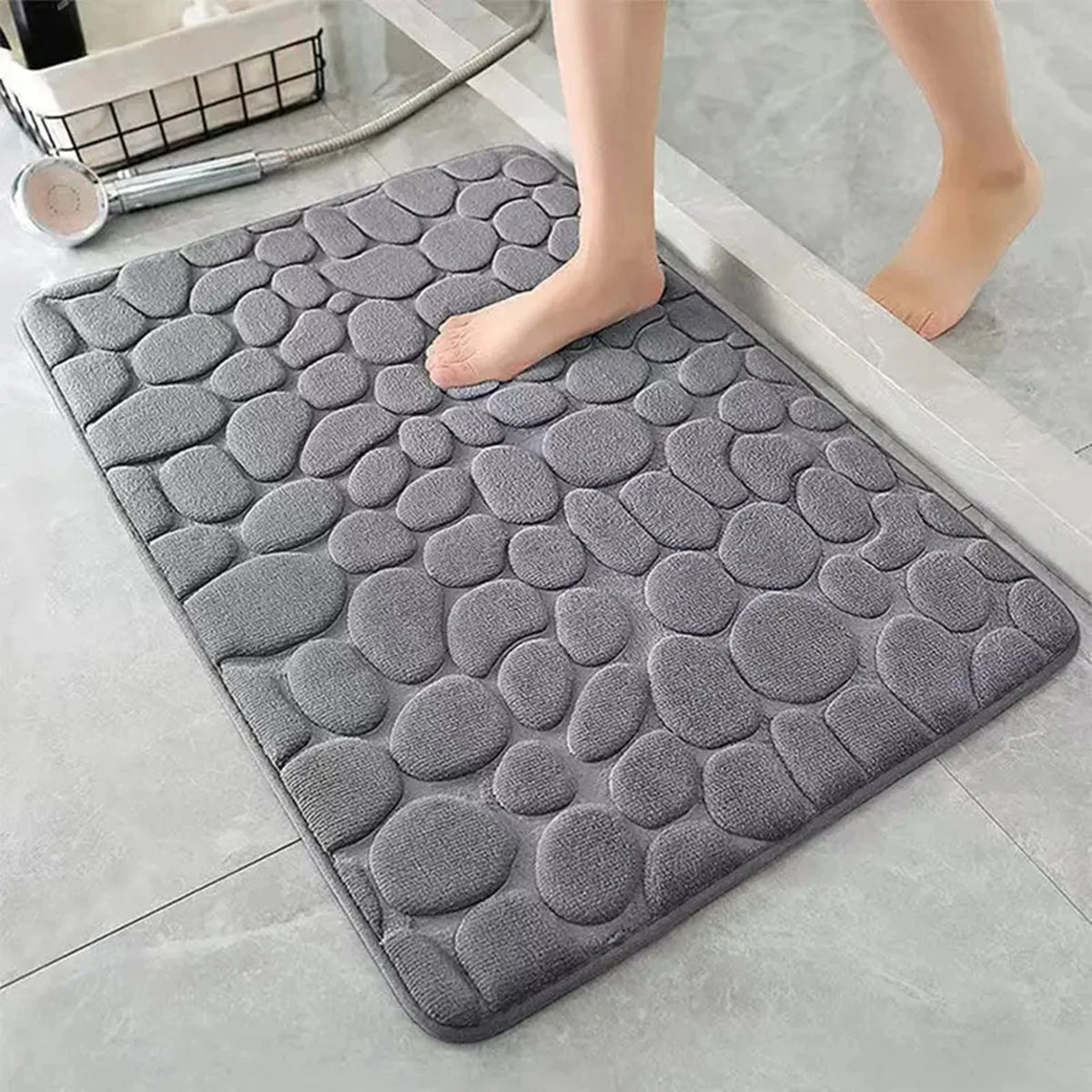 Gray cobblestone bath mat on a bathroom floor