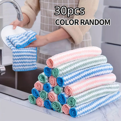 30 rolled dish cloths in assorted colors stacked by the sink