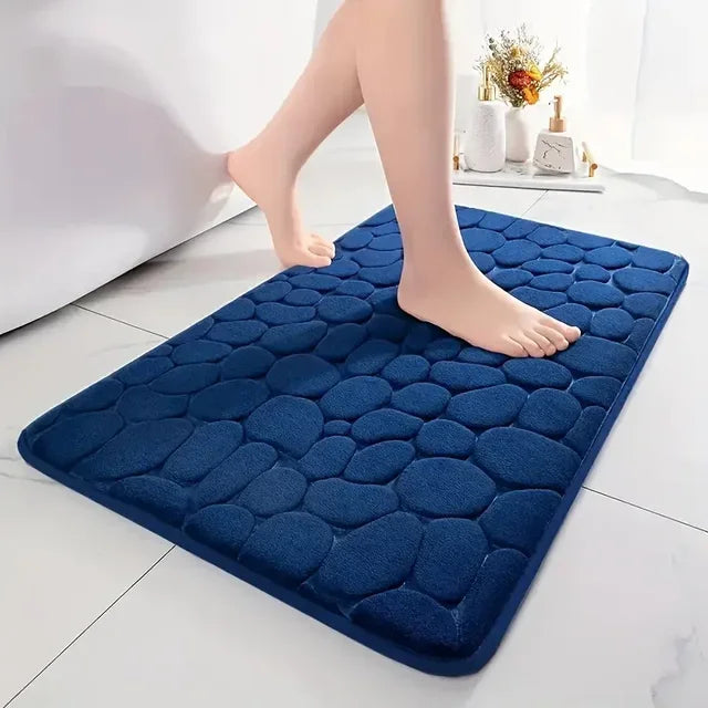 Navy Blue cobblestone bath mat on a bathroom floor