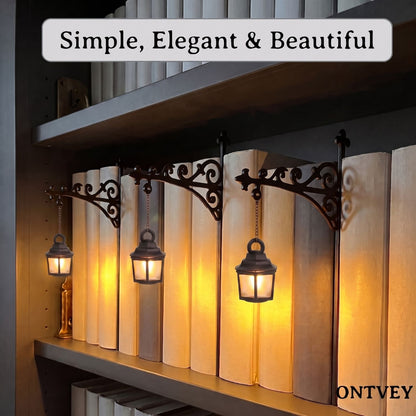 Three lantern lights glowing on a bookshelf