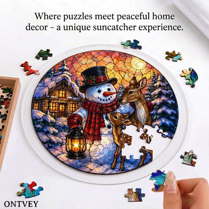 Hands assembling the Lantern Snowman & Deer acrylic jigsaw puzzle suncatcher on a table