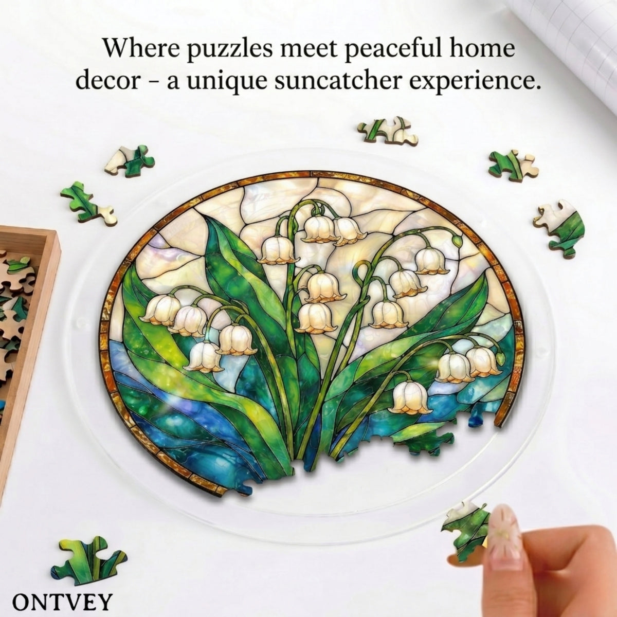 Hands assembling the Lily of the Valley acrylic jigsaw puzzle suncatcher on a table